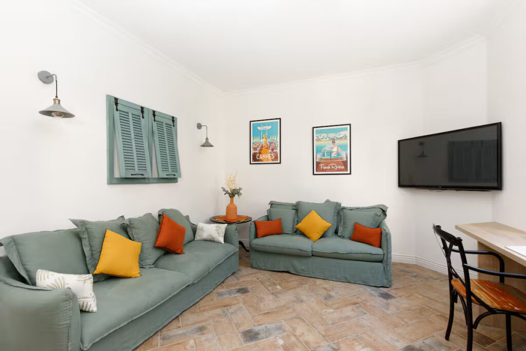 Salon lumineux avec canapés confortables et espace télévision dans une propriété de charme à Cannes