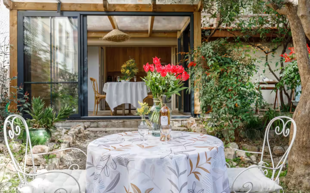 Terrasse fleurie avec table dressée dans un jardin provençal romantique et chaleureux