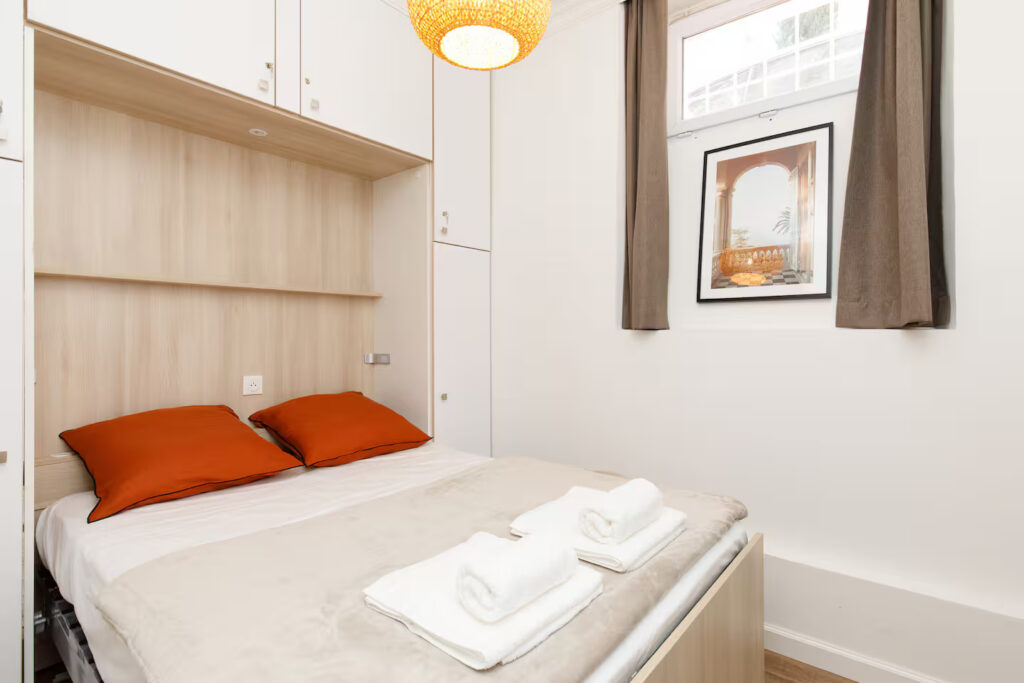 Chambre avec lit double escamotable et rangements intégrés dans un appartement à Cannes