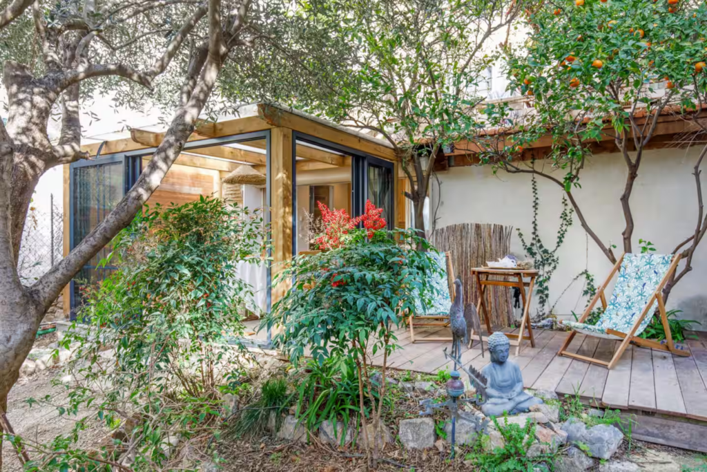 Terrasse ombragée avec fauteuils et végétation méditerranéenne dans un jardin privatif en Provence